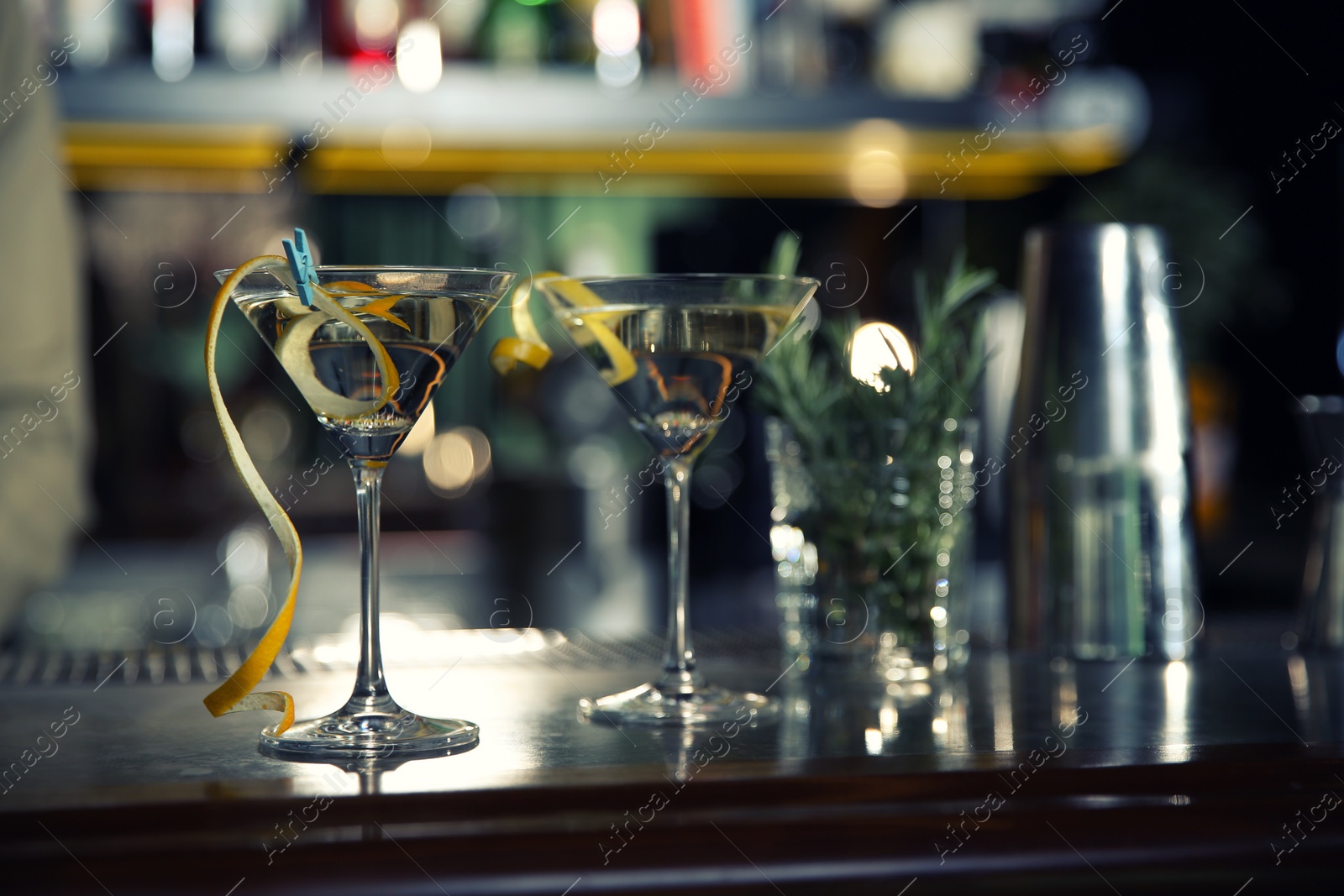 Photo of Glasses of lemon drop martini cocktail in bar. Space for text