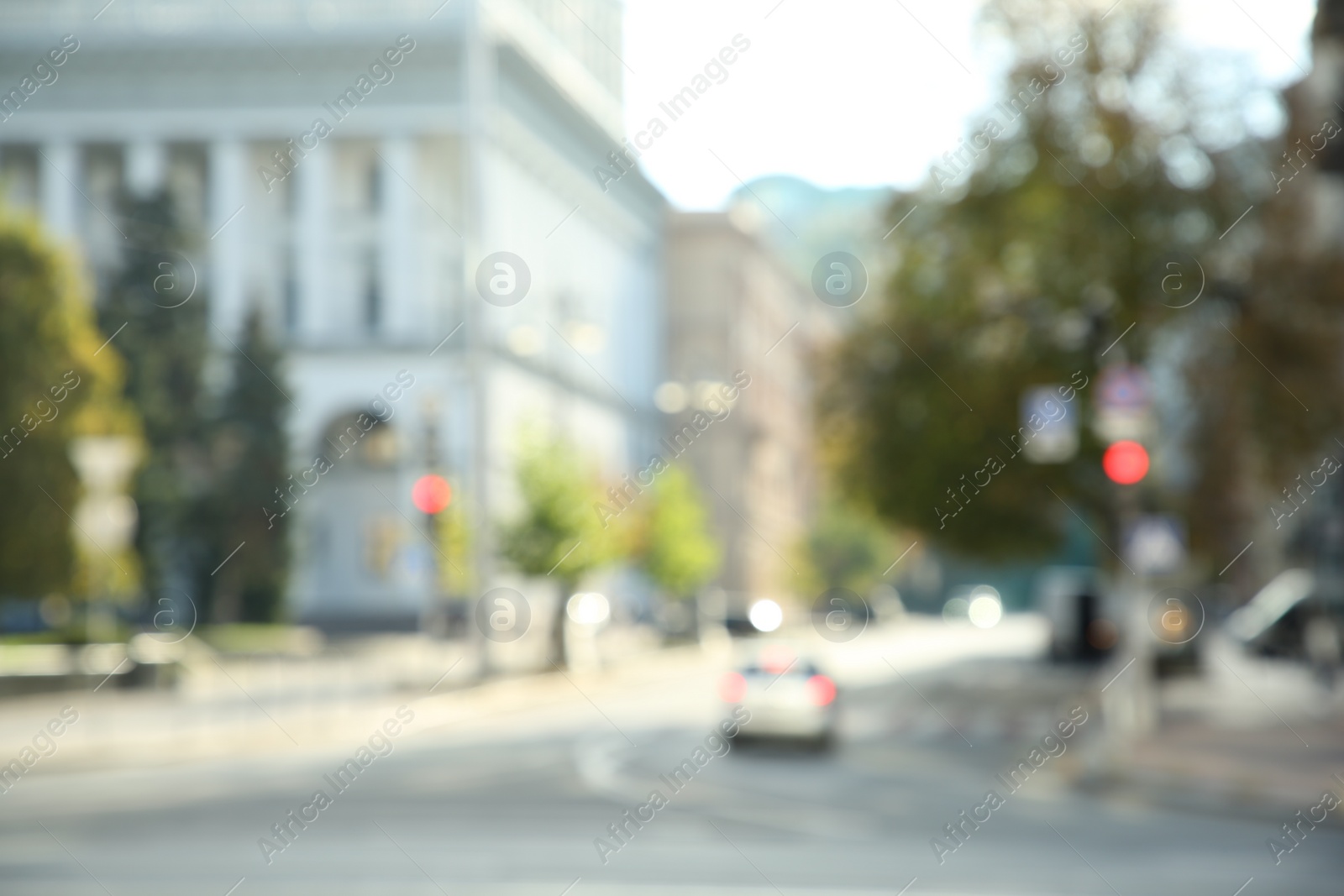 Photo of Blurred view of quiet city street car on road on sunny day