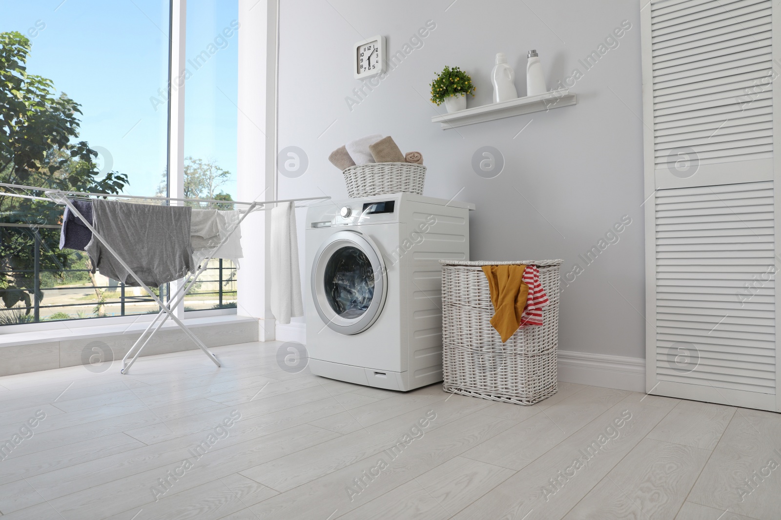 Photo of Laundry room interior with washing machine near wall