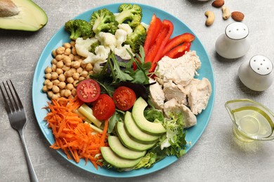 Balanced diet and healthy foods. Plate with different delicious products on grey table, flat lay