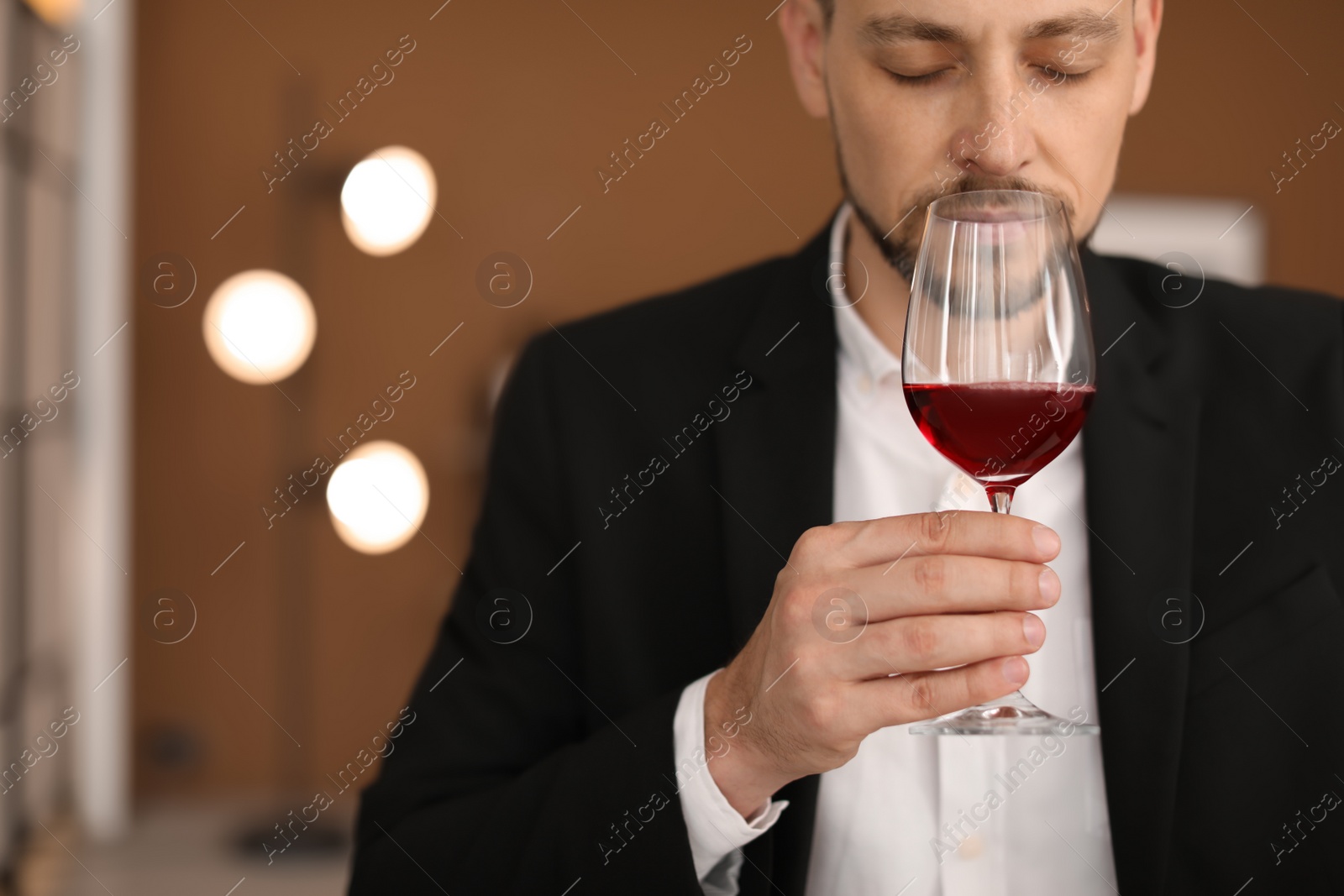 Photo of Young man with glass of wine indoors