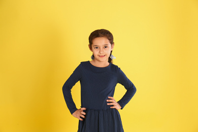 Photo of Portrait of cute little girl on yellow background