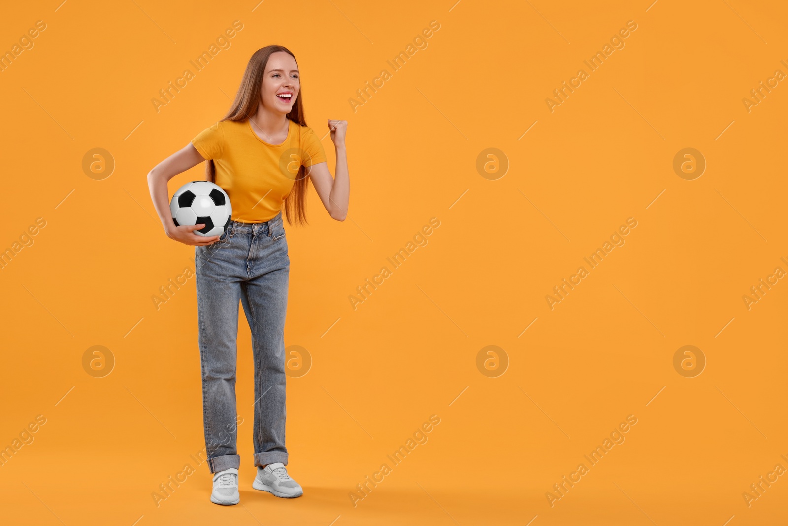 Photo of Emotional sports fan with ball on yellow background. Space for text