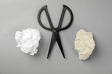 Photo of Flat lay composition with rock, paper and scissors on grey background