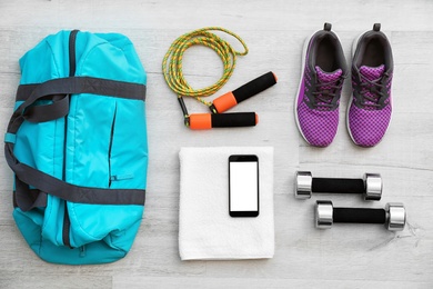 Flat lay composition with sports bag on wooden floor