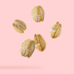 Image of Rolled oat flakes falling on pink background