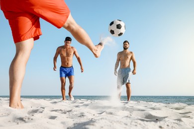 Photo of Group of friends playing football on beach