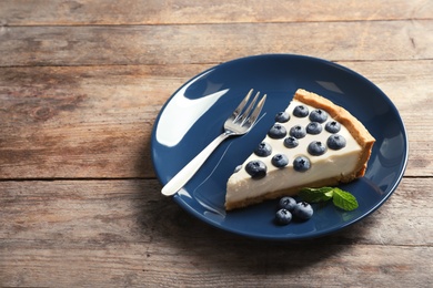 Plate with tasty blueberry cake on table. Space for text