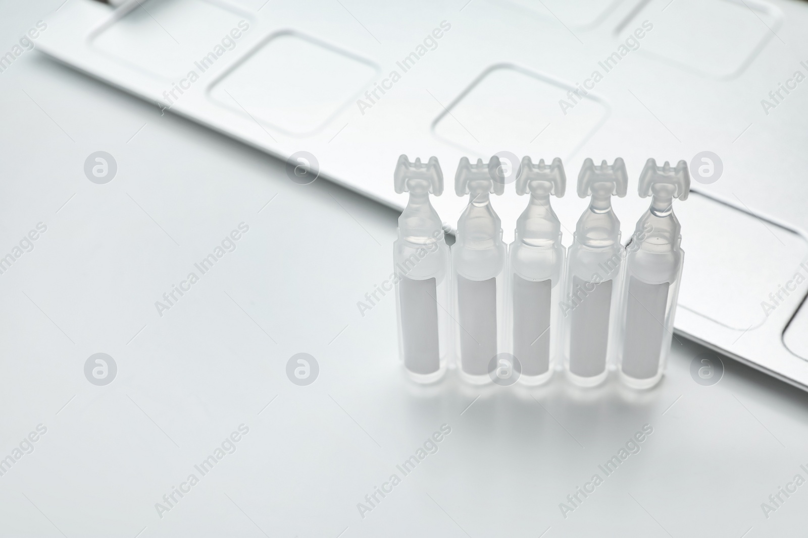 Photo of Single dose ampoules of sterile isotonic sea water solution on white background. Space for text