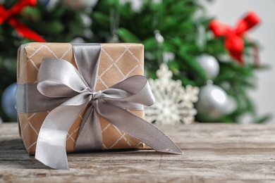 Photo of Beautiful gift box and blurred Christmas tree on background