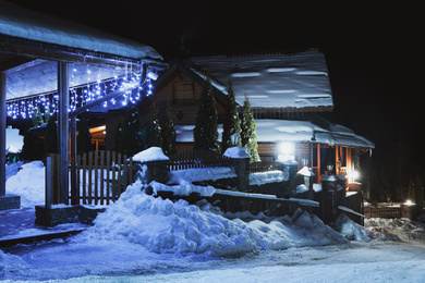 Modern cottage covered with snow at night. Winter vacation