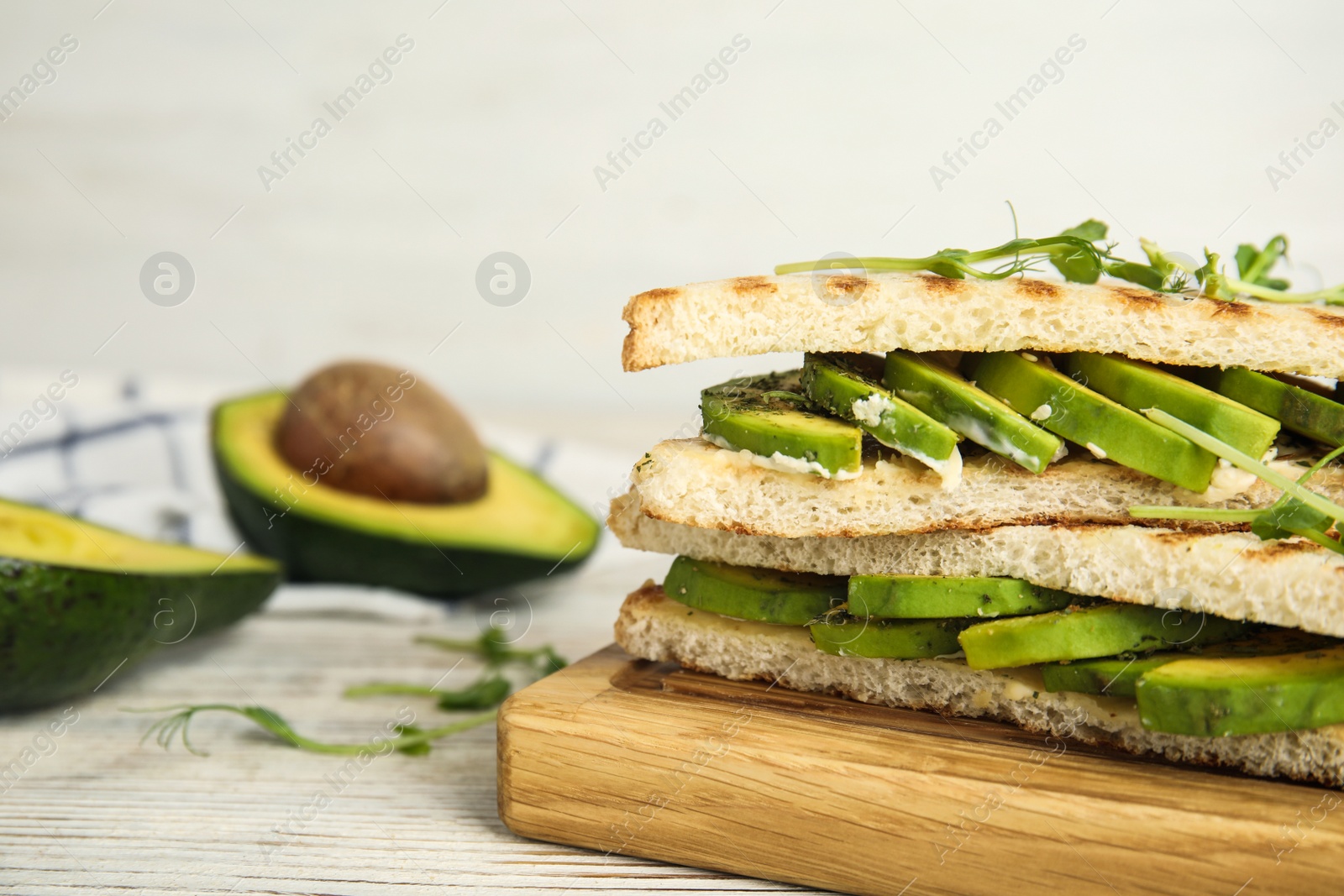 Photo of Tasty avocado sandwiches on white wooden table, closeup