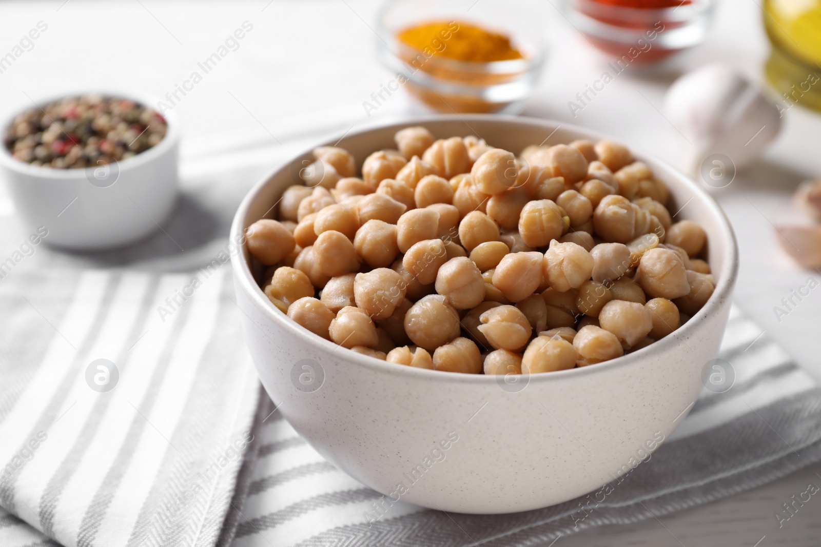 Photo of Bowl with delicious chickpeas on table, closeup