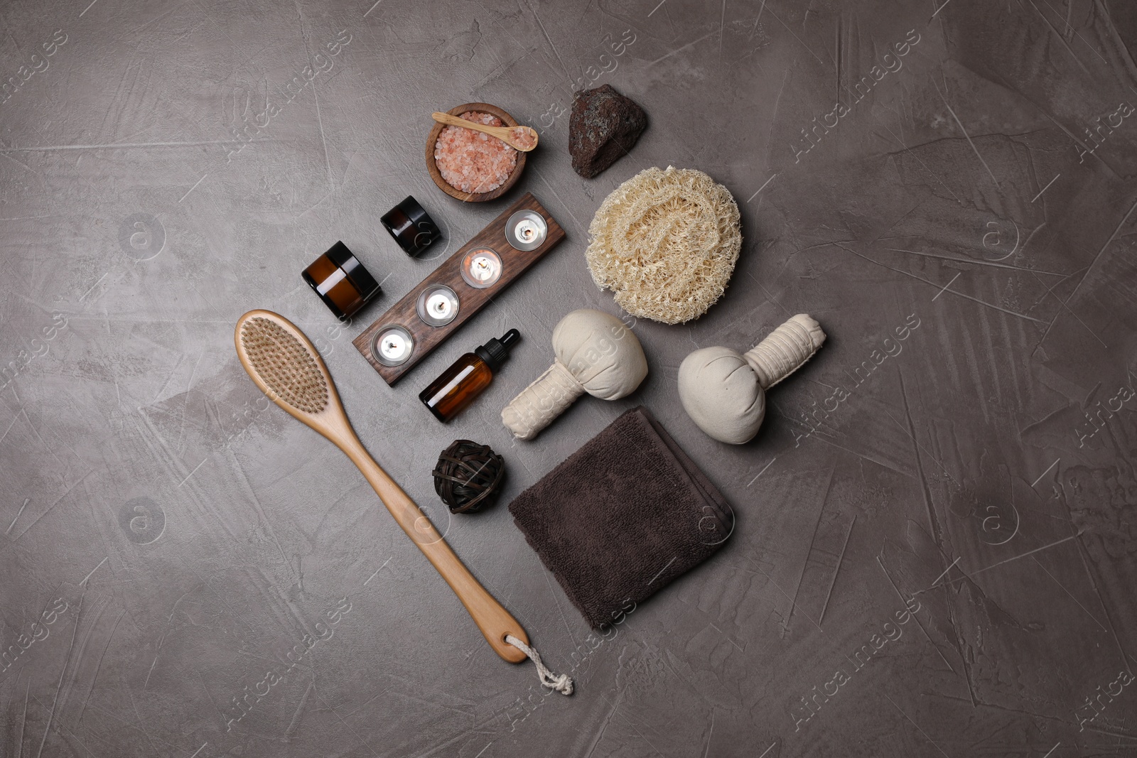 Photo of Flat lay composition with different spa products and burning candles on grey textured table