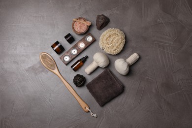Photo of Flat lay composition with different spa products and burning candles on grey textured table