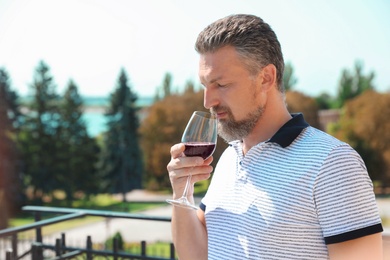 Photo of Man with glass of red wine outdoors