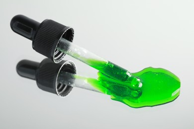 Photo of Green serum and pipette on mirror, closeup