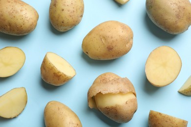 Photo of Fresh raw potatoes on light blue background, flat lay