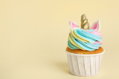 Photo of Cute sweet unicorn cupcake on beige background. Space for text