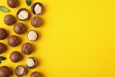 Tasty Macadamia nuts on yellow background, flat lay. Space for text