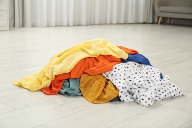 Photo of Pile of dirty clothes on floor indoors