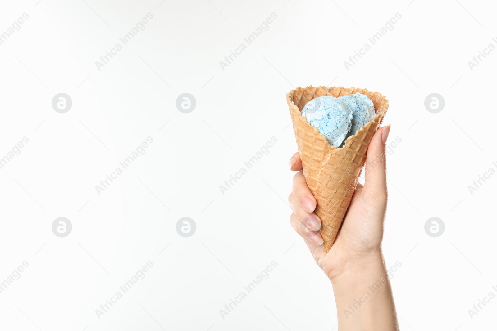 Photo of Woman holding delicious ice cream in waffle cone on white background, closeup