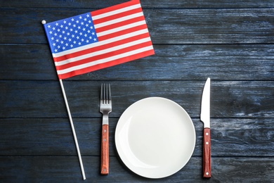 Patriotic table setting with USA flag on wooden background, flat lay