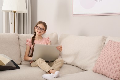 Photo of Thoughtful girl with laptop on sofa at home
