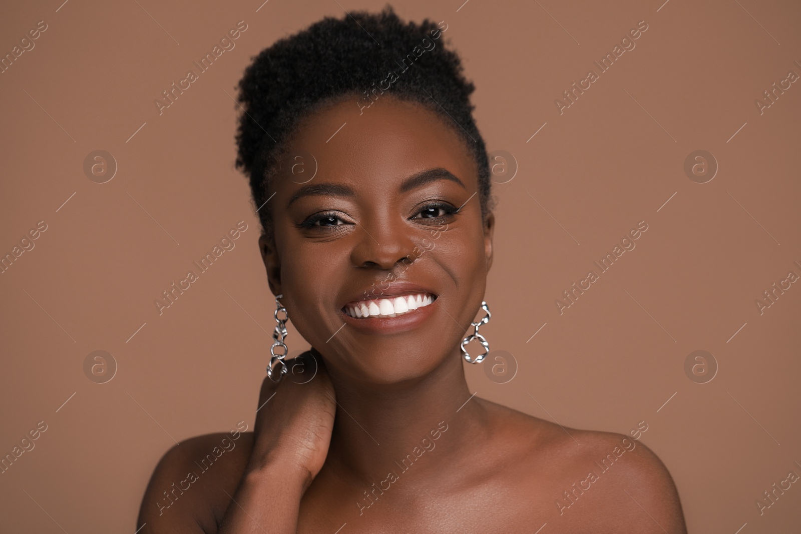Photo of Fashionable portrait of beautiful happy woman on light brown background