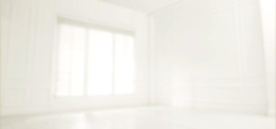 Empty room with white walls and large window, blurred view. Banner design