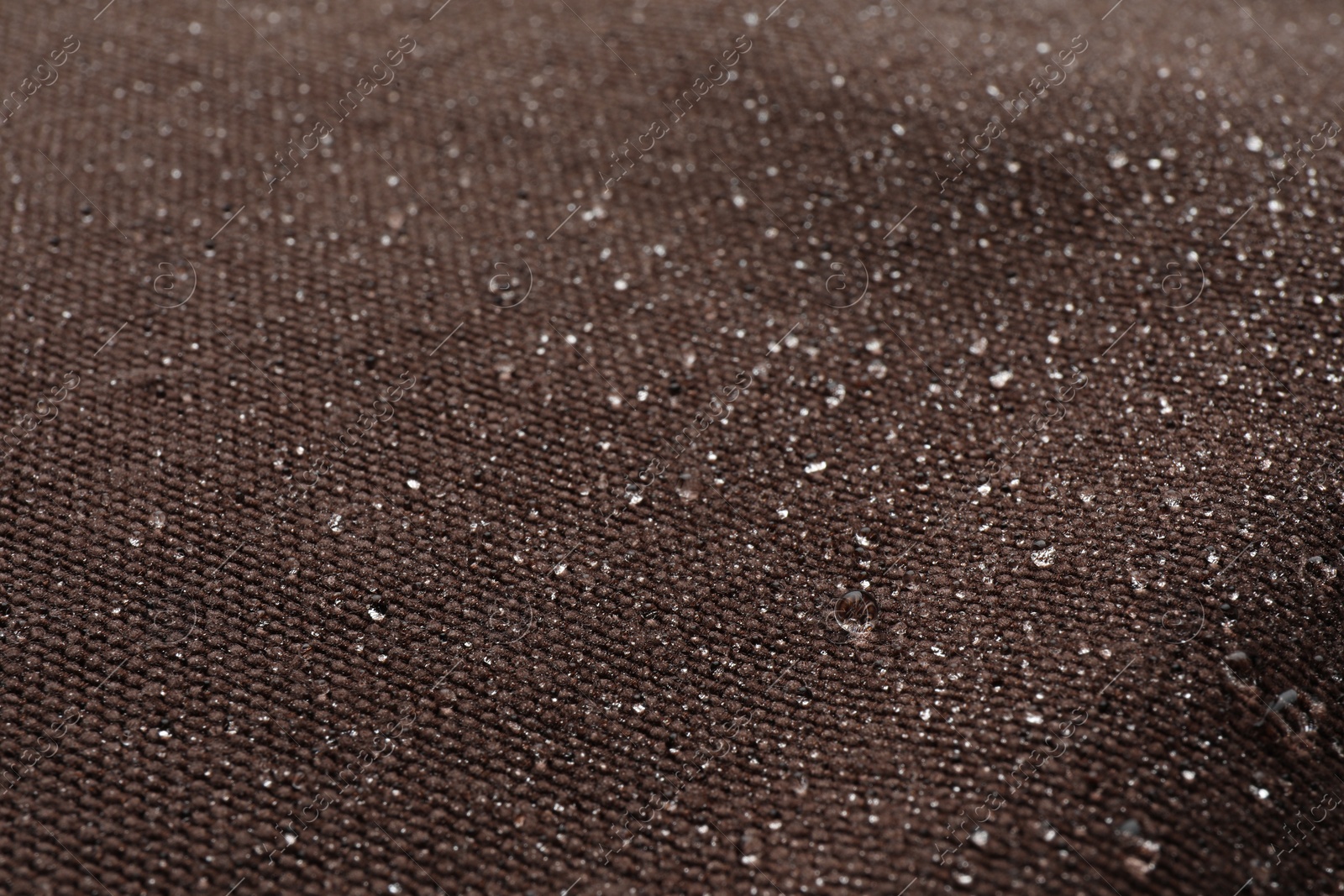 Photo of Texture of brown fabric with water drops as background, closeup