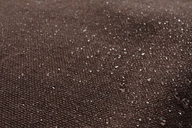 Texture of brown fabric with water drops as background, closeup