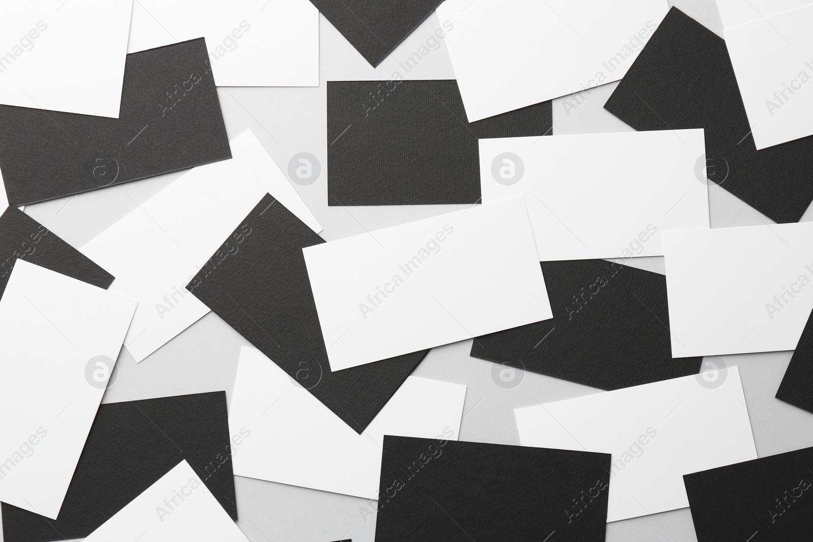 Photo of Blank black and white business cards on light background, flat lay. Mockup for design