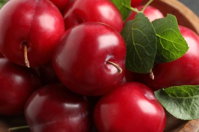Photo of Delicious ripe cherry plums with leaves, closeup