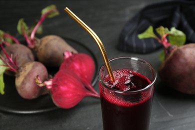 Photo of Freshly made beet juice on black table, closeup view