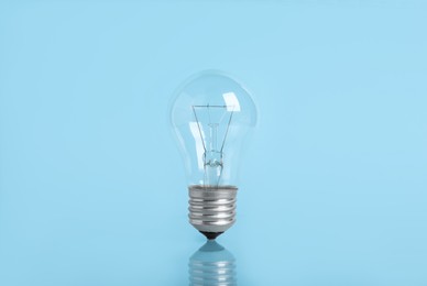 Photo of New modern light bulb on color background