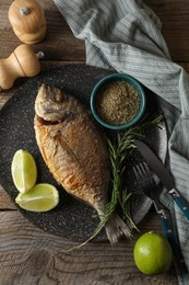 Photo of Delicious dorado fish served on wooden table, flat lay