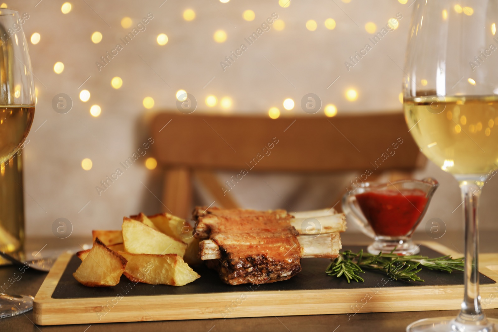 Photo of Fried ribs served with garnish, sauce and wine on table, space for text. Delicious meat