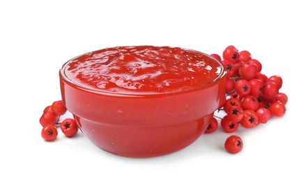 Delicious rowan jam in glass bowl and berries on white background