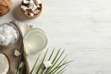 Photo of Flat lay composition with coconut oil on white wooden table, space for text