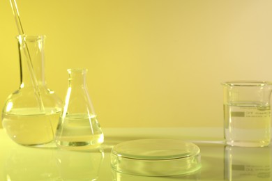 Laboratory analysis. Different glassware on table against yellow background