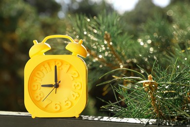 Yellow alarm clock outdoors on sunny morning. Space for text