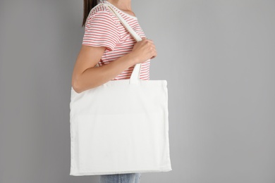 Photo of Woman with tote bag on grey background. Mock up for design