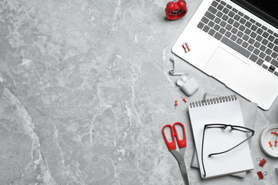 Flat lay composition with laptop and stationery on grey marble table, space for text. Designer's workplace