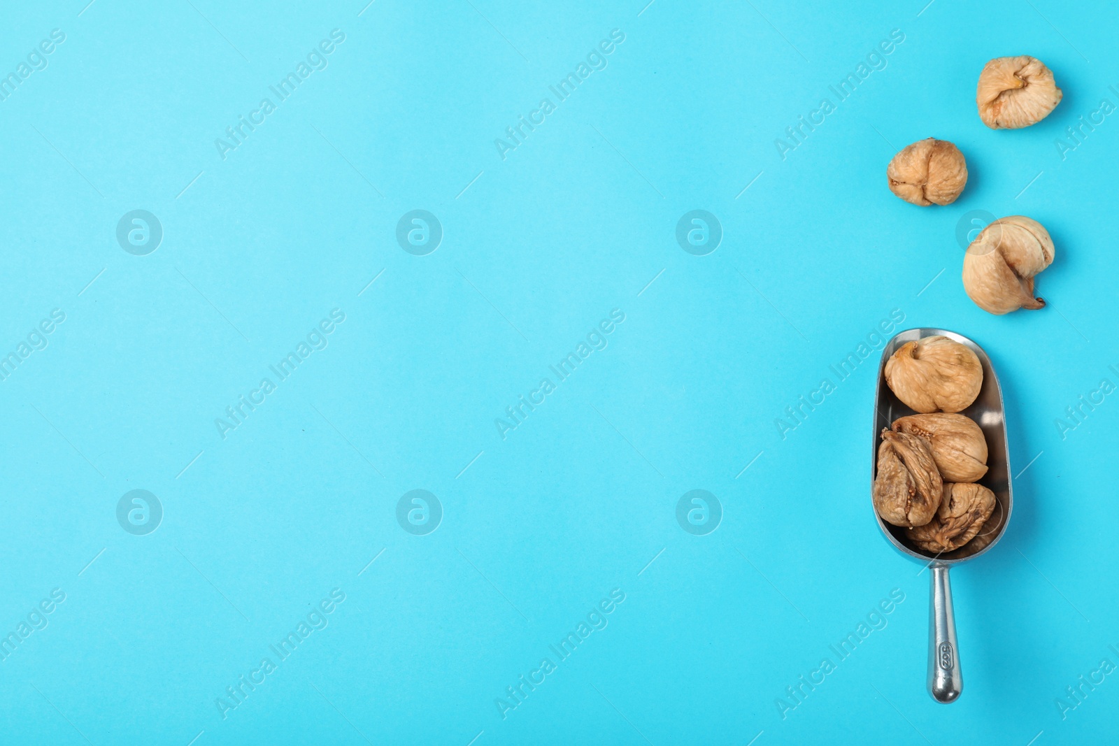 Photo of Scoop of dried figs on color background, top view with space for text. Healthy fruit