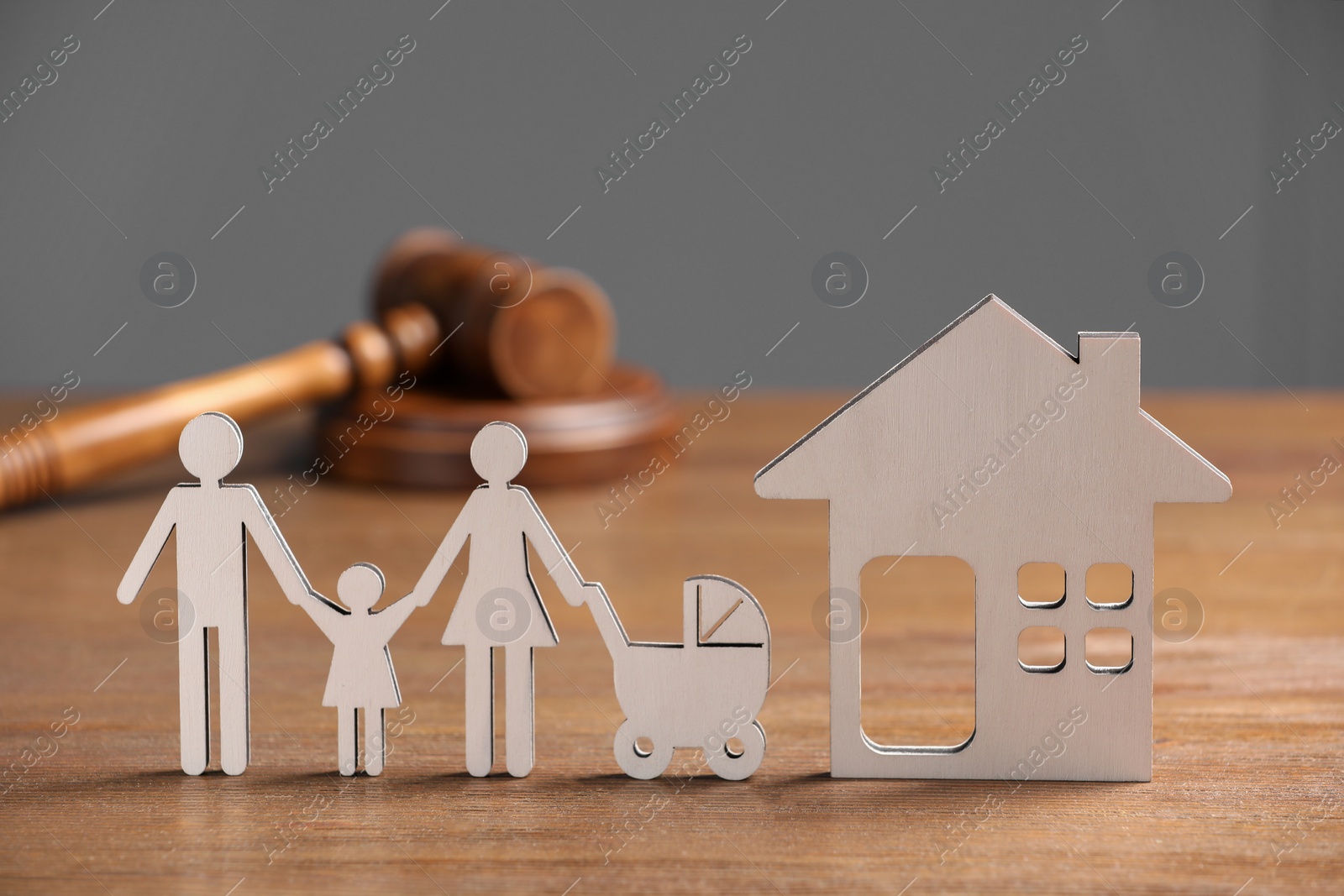 Photo of Family law. Figure of parents with children, house model and gavel on wooden table