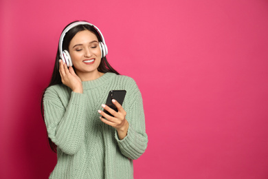 Photo of Young woman listening to audiobook on pink background. Space for text