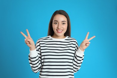 Photo of Woman showing number four with her hands on light blue background