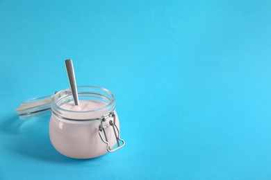 Photo of Jar with tasty yogurt on color background