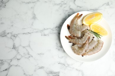 Photo of Fresh raw shrimps with lemon and rosemary on marble table, top view. Space for text